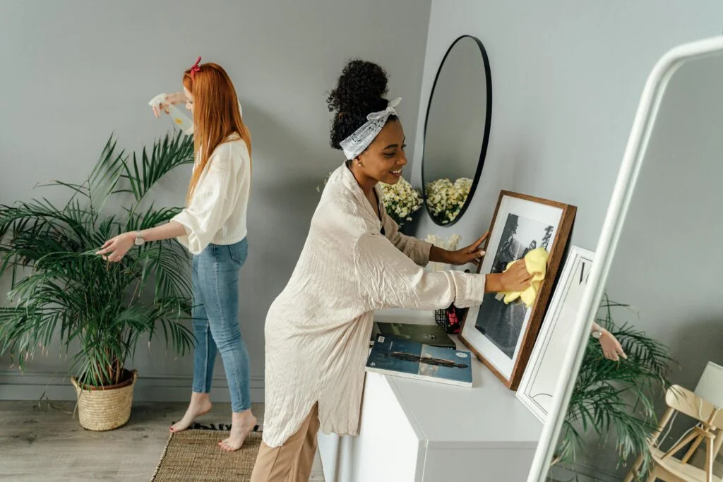 Dos personas realizando tareas de limpieza en una habitación